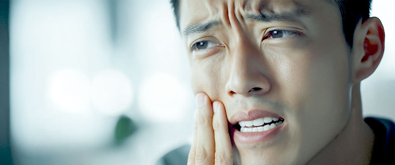 Man Holding Cheek Due to Dental Issues